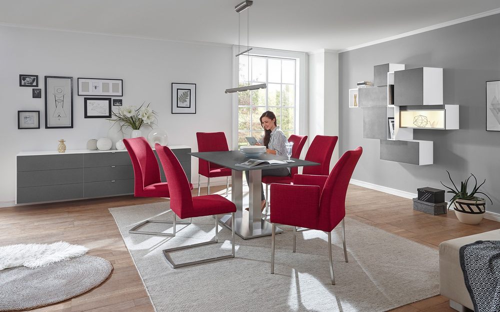 Graue Esszimmermöbel mit roten Stühlen